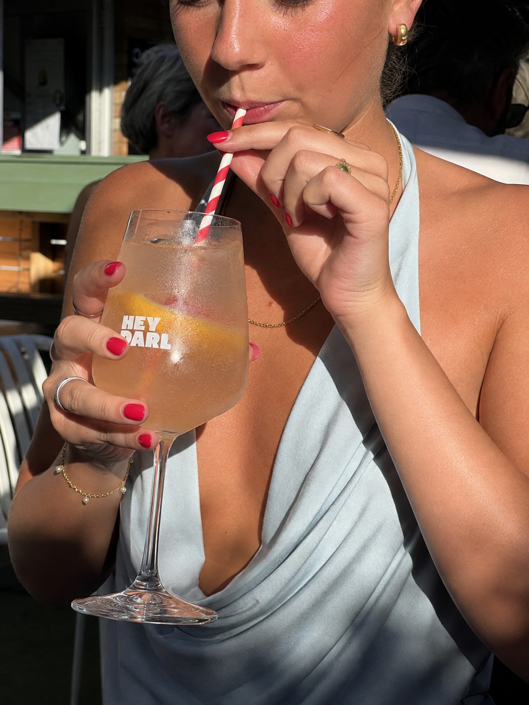 A customer sipping a drink from a Hey Darl glass